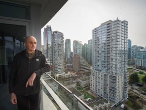 Ian Gilhooley stands on the balcony of his condo on West Cordova street in Vancouver, B.C., March 4, 2020. Saturday feature about skyrocketing cost of condo insurance and the many people affected.