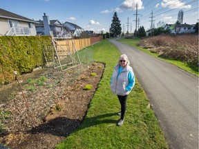 Myrna Funk stands along path where numerous community gardens have been built in Langley.