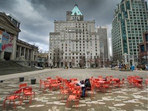 A lone man sits reading in an empty area in front of the Vancouver Art Gallery on March 23.