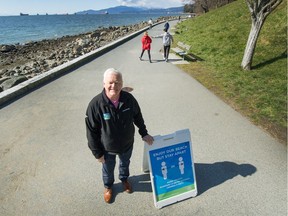 Malcolm Bromley, general manager of Vancouver parks board, with social distancing signs on the Seawall.