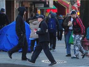 The street is crowded as welfare cheques are distributed in Vancouver's Downtown Eastside on Wednesday.