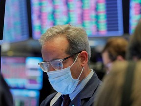 A trader wears a mask as he works on the floor of the New York Stock Exchange as the building prepares to close indefinitely due to the coronavirus disease outbreak in New York on Friday.