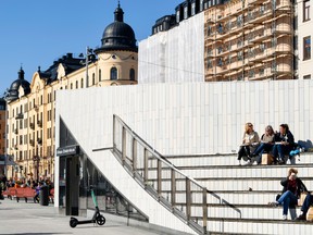 People sits in an amphitheater in the Odenplan town square in Stockholm, Sweden, on Thursday, March 26, 2020.