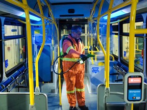 A worker sprays disinfectant on a TransLink bus in Vancouver.