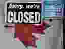 A 'Closed' sign hangs in a store window on April 16, 2020.