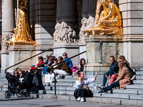 People sit and enjoy the spring weather outside the Royal Dramatic Theatre in Stockholm on April 15, 2020, during the coronavirus COVID-19 pandemic.