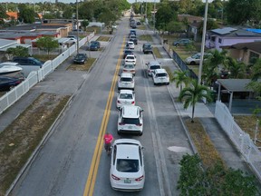 Signs of the economic fallout from COVID-19: Drivers in vehicles lined up on a road, as far as the eye can see, as they wait to receive unemployment applications in Hialeah, Fla., last week. Political leaders are being required to balance forecasts about fatalities from COVID-19 against forecasts about the damage caused to hundreds of millions of lives by a drastic economic shutdown.