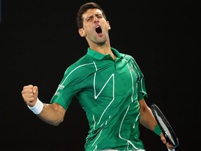 Serbia's Novak Djokovic reacts after winning his first set against Canada's Milos Raonic during their men's singles quarter-final match on day nine of the Australian Open tennis tournament in Melbourne on January 28, 2020.