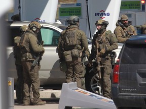 Members of the Royal Canadian Mounted Police (RCMP) tactical unit confer after the suspect in a deadly shooting rampage was neutralized at the Big Stop near Elmsdale, Nova Scotia, Canada, on April 19, 2020.