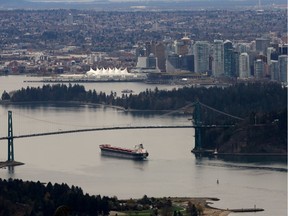 A cargo ship passes under Lions Gate Bridge into the Port of Vancouver,