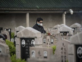 A visitor wearing a protective mask stands in a public cemetery during the Qingming Festival in Shanghai, China, on Saturday, April 4, 2020.