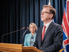 B.C. Health Minister Adrian Dix, with Provincial Health Officer Dr. Bonnie Henry in the background, doesn't have a problem with Canadians returning home during the COVID-19 pandemic, but wants to ensure they are tested, go home and stay home for at least 14 days.