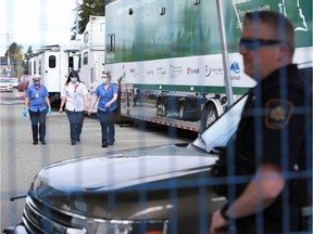 Medical workers and a prison guard are seen at a secure mobile medical unit set up at Abbotsford Regional Hospital to treat prisoners infected with COVID-19 from the Mission Institution correctional facility.
