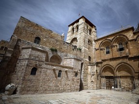 A man prays in front of the closed doors of the Church of the Holy Sepulchre on Palm Sunday, during Holy Week amid the coronavirus disease (COVID-19) outbreak, in Jerusalem's Old City on April 5, 2020.