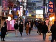 People wearing face masks to protect themselves against contracting the new coronavirus walk on a street in central Seoul, South Korea April 22, 2020.