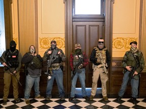 A militia group with no political affiliation from Michigan stands in front of the Governors office after protesters occupied the state capitol building during a vote to approve the extension of Governor Gretchen Whitmer's emergency declaration/stay-at-home order due to the coronavirus disease (COVID-19) outbreak, at the state capitol in Lansing, Michigan, U.S. April 30, 2020.  REUTERS/Seth Herald