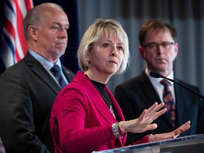 Provincial health officer Dr. Bonnie Henry responds to questions while B.C. Premier John Horgan, back left, and Health Minister Adrian Dix listen during a news conference about the provincial response to the coronavirus, in Vancouver, on March 6, 2020.