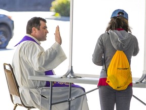 Father Nick Meisl at St. Patrick's Catholic parish in Vancouver, offering confession in parking lot.