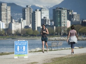 Joggers at Vanier Park in Vancouver, BC Saturday, April 18, 2020. The City of Vancouver has posted signs in parks and beaches reminding users to keep apart.