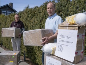 Steve Merritt, right, and Dave Sandover move some boxes of the 2,000 N95 masks they're donating to Vancouver General Hospital, in Vancouver on April 13.