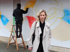 Robson Street Business Association president Teri Smith, in front of murals being painted on boarded-up store windows.