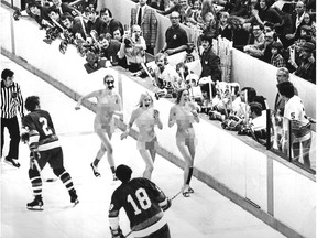 Three streakers hit the ice at the Vancouver Canucks/New York Islanders game at the Pacific Coliseum on March 30, 1974. Province photographer Bill Cunningham took this photo, but it didn't run in the paper. The game was broadcast across Canada on CBC's Hockey Night in Canada - note the TV cameraman filming in between the benches. Bill Cunningham/Province