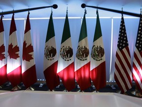 National flags representing Canada, Mexico, and the U.S. are lit by stage lights at the North American Free Trade Agreement, NAFTA, renegotiations, in Mexico City, Tuesday, Sept. 5, 2017.