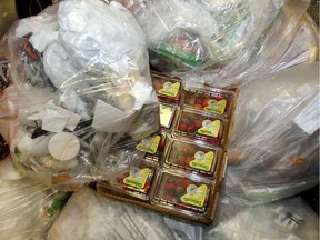 Boxes of strawberries sit among bags of trash in this archive image.