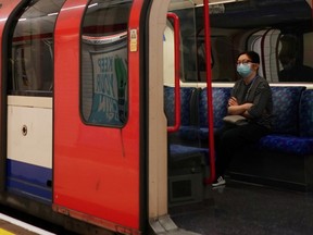 A commuter wearing a mask sits on a train at London Liverpool Street Station, following the outbreak of the coronavirus disease (COVID-19), London, Britain, May 13, 2020.