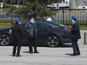 Limo drivers wearing face masks wait for fares in the designated parking lot outside of Terminal 3 at Pearson International Airport.