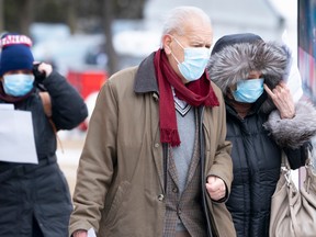 An elderly couple lines up outside a walk-in COVID-19 test clinic in Montreal on Monday, March 23, 2020.