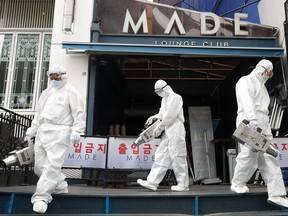Quarantine worker spray disinfectants in front of a night club on the night spots in the Itaewon neighborhood, following the coronavirus disease (COVID-19) outbreak, in Seoul, South Korea, May 12, 2020.