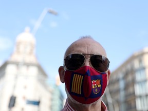 A man wearing a protective mask with colours of the Catalunya flag and Barcelona football club crest poses for a picture, as some Spanish provinces are allowed to ease lockdown restrictions during phase one, amid the coronavirus disease (COVID-19) outbreak in Barcelona, Spain, May 25, 2020.
