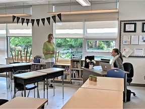 Vancouver Superintendent of Schools Suzanne Hoffman (standing) and teacher Brianne Fenrich at L’Ecole Bilingue in Vancouver. B.C. school administrators and teachers are preparing classrooms for the part-time return of some students next week.
