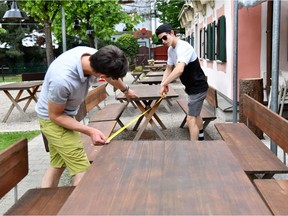 Staff at the FuxnGut restaurant measure distance between tables as they prepare their premises for reopening in Salzburg, central Austria on April 28, 2020.