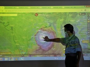 A scientist at India Meteorological Department Earth System Science Organization points to a section of the screen showing the position of the Cyclone Amphan to reporters in his office in Kolkata, India, on May 19, 2020.