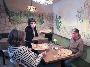 Guests receive pizza in the restaurant 'Tuscolo' that reopened on Monday, May 11, 2020, following weeks of closure due to the global outbreak of the coronavirus disease (COVID-19), in Bonn, Germany.