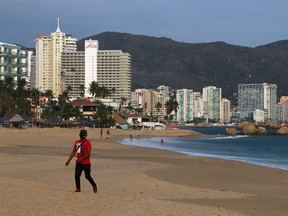 A man walks at an almost empty beach during the coronavirus disease (COVID-19) outbreak in Acapulco, Mexico May 26, 2020.