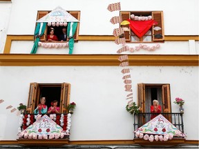 Women on their balconies in Spain applaud the festivities outside.