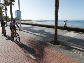 People cycle and walk on the promenade of Arrecife beach, during the hours in which individual exercise is allowed outdoors, amid the coronavirus disease (COVID-19) outbreak on the island of Lanzarote, Spain, May 3, 2020.