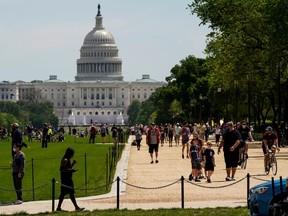People gather on the National Mall in Washington, D.C. on Saturday, May 2, 2020, awaiting a formation of the U.S. Navy Blue Angels and the U.S. Air Force Thunderbirds to fly over as a salute to first responders and other essential personnel during the ongoing COVID-19 coronavirus crisis.