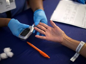 A person receives a test for diabetes during Care Harbor LA free medical clinic in Los Angeles, California September 11, 2014.