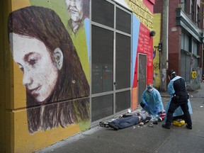 Ambulance paramedics help a man suffering a drug overdose on Columbia Street in Vancouver's Downtown Eastside Saturday, May 2, 2020. The man survived.