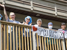 Betty Wills, director of care, appearing directly above the letter "T", joins other staff members on a balcony at the Lynn Valley Care Centre on Tuesday.