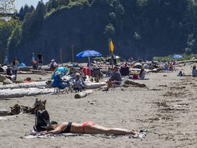 People out enjoying the warm sunny weather on Ambleside beach in West Vancouver on May 8, 2020. A long lens makes them appear closer together than in reality.