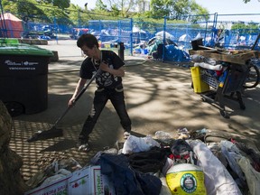 Kim Berg, who until Friday lived at Oppenheimer Park, helps sweep debris Saturday. Oppenheimer Park in Vancouver's Downtown Eastside was cleared Saturday, May 9, 2020 of campers, but not their tents and other assorted items, on schedule as imposed by the provincial government. Several residents of the park moved to Crab Park on the waterfront, setting up tents on Vancouver Port Authority land.