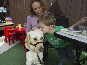 Rebecca Stevens with her seven-year-old son Nate Rosenczweig-Stevens and his autism assistance guide dog Boma, at their home in Surrey.