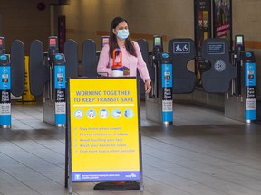 A passenger with facemask exits the Broadway-City Hall SkyTrain station on Tuesday.