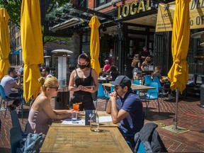 Servers at Local Public Eatery in Gastown with customers on May 26, 2020.