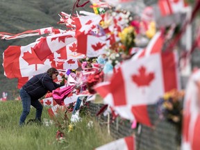 Jennifer McElory of Kamloops places her memorial on the Kamloops Airport fence on Thursday May 21 , 2020. Capt. Casey, a Snowbirds public affairs officer, died after the Snowbirds jet she was in crashed shortly after takeoff.